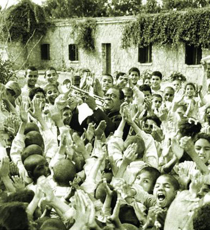 Louis Armstrong zabawia dzieci w centrum medycznym Tahhseen Al-Sahha, Kair, Egipt, 1961